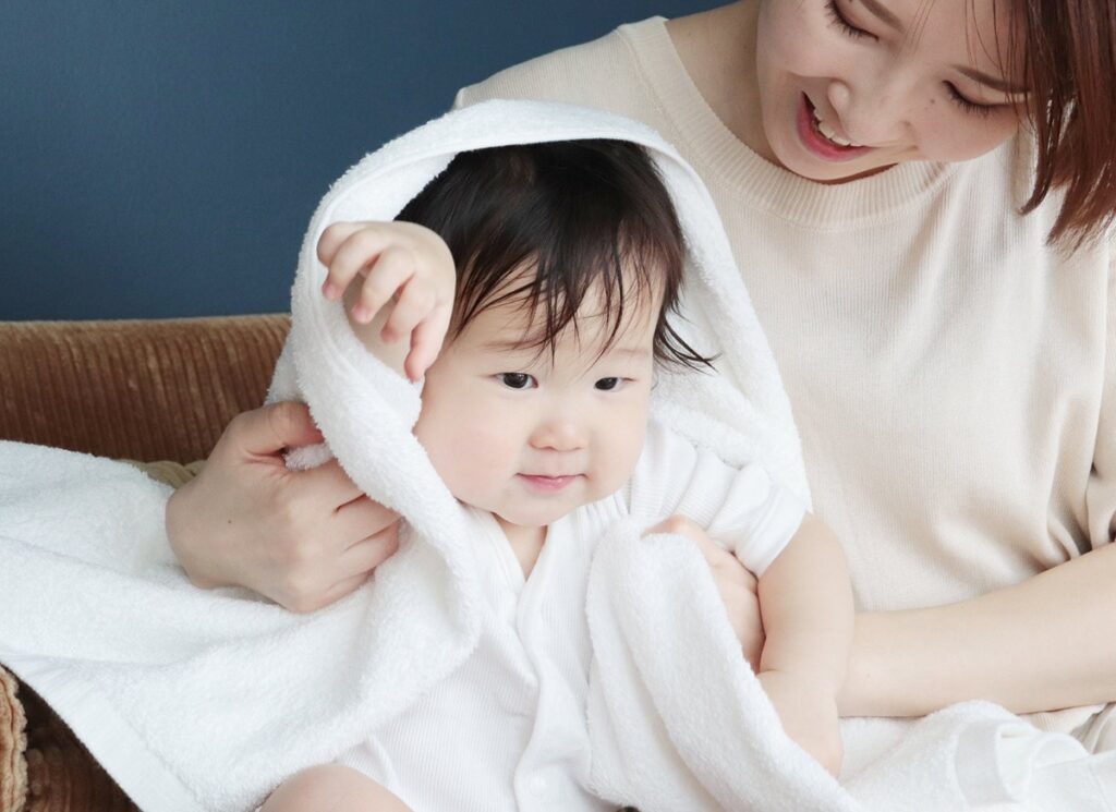 ホテルスタイルタオルで赤ちゃんをやさしく包む様子